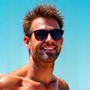 Porträtfoto von David Peter, einem entspannten Mann mit Sonnenbrille am Strand